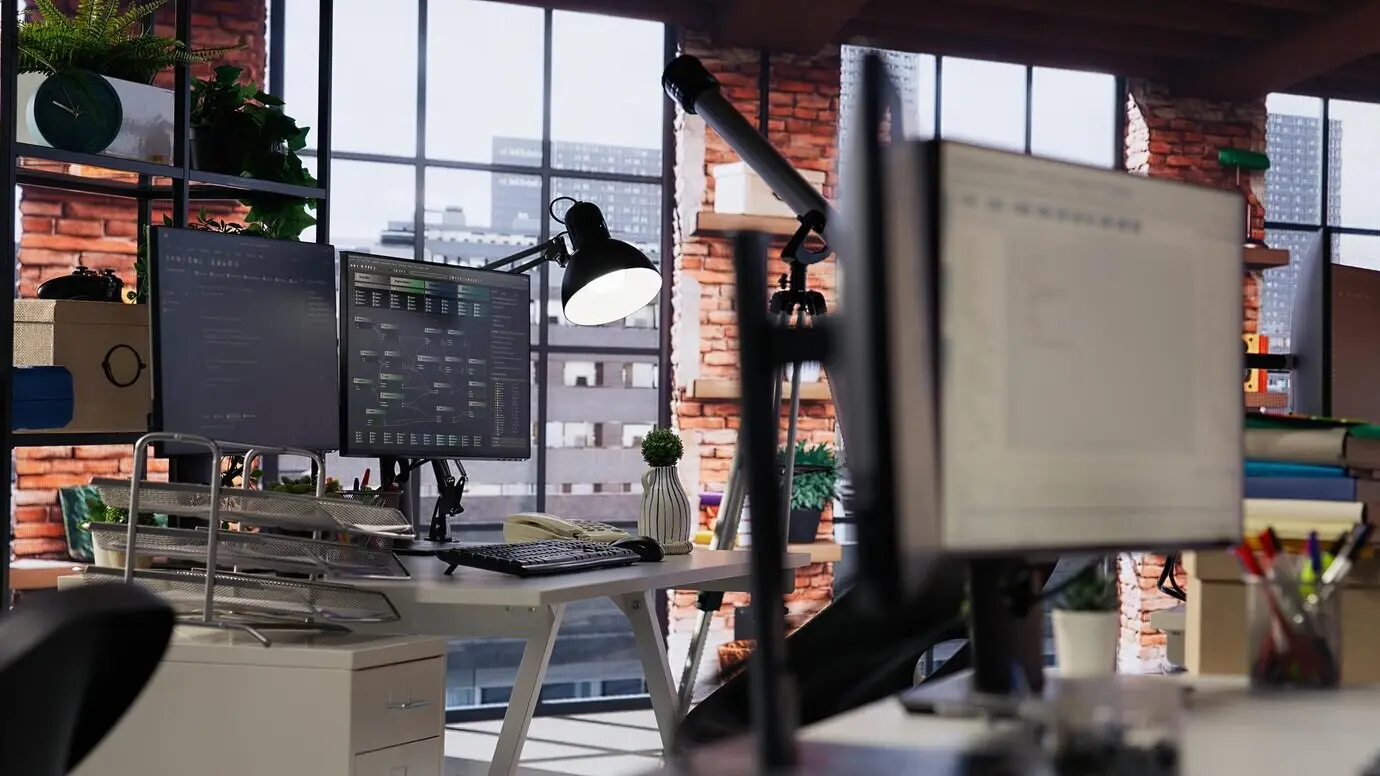 Экран компьютера с отображаемым кодом в пустом офисе агентства по разработке программного обеспечения.